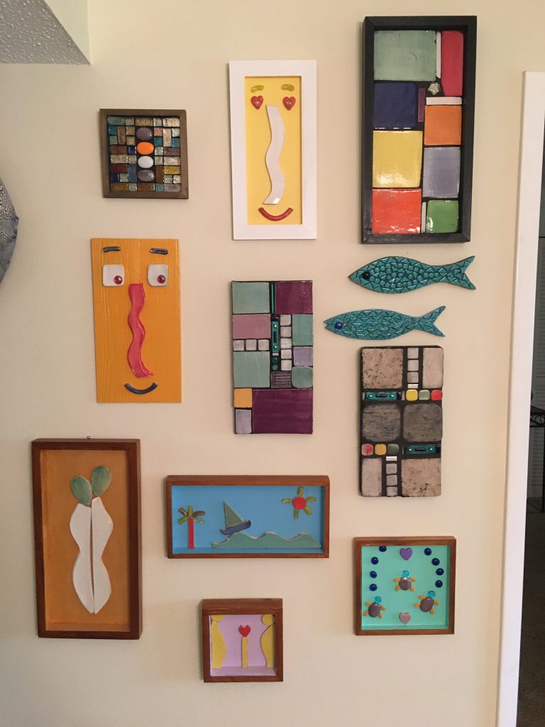 A slection of Margo's art hanging on a wall.